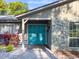 Inviting front entrance featuring a vibrant blue door and a stone accent wall with manicured landscaping at 4404 Hickory Branch Ct, Brandon, FL 33511