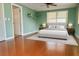 Light-filled bedroom features a gray bed, wood floors, and green walls at 4407 Westwood Dr, Holiday, FL 34691