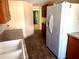 Kitchen with wood cabinets, hardwood floors, and white refrigerator at 4407 Westwood Dr, Holiday, FL 34691