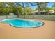 Sparkling in-ground pool surrounded by a screened enclosure and trees at 4407 Westwood Dr, Holiday, FL 34691