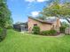 Backyard view featuring a screened pool, lush green lawn, and mature trees, creating a serene outdoor space at 4610 Westford Cir, Tampa, FL 33618