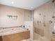 Bathroom featuring an elegant tub and seamless glass shower with neutral tile at 4610 Westford Cir, Tampa, FL 33618