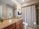 Bathroom with granite countertops, wood cabinets, and a shower-tub combo at 4610 Westford Cir, Tampa, FL 33618