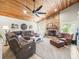 Well lit living room featuring a stone fireplace, wood ceilings, and comfortable seating at 4610 Westford Cir, Tampa, FL 33618