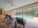 Relaxing covered patio with comfortable seating overlooking a screened-in pool and lush backyard at 4610 Westford Cir, Tampa, FL 33618