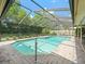 Beautiful screened pool area surrounded by lush landscaping, offering a private outdoor oasis at 4610 Westford Cir, Tampa, FL 33618