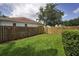 Grassy backyard with a wood fence at 4736 Stonebriar Dr, Oldsmar, FL 34677