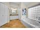 Bright bathroom featuring a garden tub, glass block window, and granite vanity at 4736 Stonebriar Dr, Oldsmar, FL 34677