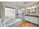 Bright bathroom featuring a walk-in shower, garden tub, glass block window, and granite vanity at 4736 Stonebriar Dr, Oldsmar, FL 34677