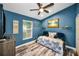 Cozy bedroom features blue walls, a ceiling fan, and wood-look floors at 4736 Stonebriar Dr, Oldsmar, FL 34677