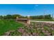 Welcoming entrance to East Lake Woodlands with blooming flowers, manicured lawns, and clear blue skies at 4736 Stonebriar Dr, Oldsmar, FL 34677