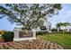Ardea Country Club entrance featuring a stone sign, manicured lawn, flower beds, and building exterior at 4736 Stonebriar Dr, Oldsmar, FL 34677