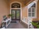 Charming front porch with double doors, bench seating, and decorative planters at 4736 Stonebriar Dr, Oldsmar, FL 34677