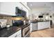 Modern kitchen with stainless steel appliances, granite countertops, and a mosaic backsplash at 4736 Stonebriar Dr, Oldsmar, FL 34677
