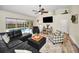 Open living room boasts a black sectional, flat screen TV and a sliding glass door that provides access to the pool at 4736 Stonebriar Dr, Oldsmar, FL 34677