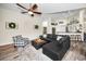 Open floor plan living room with dark brown sectional, gray accent chair, and hardwood floors throughout at 4736 Stonebriar Dr, Oldsmar, FL 34677
