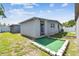 View of the backyard featuring an outdoor shed, a small patio, and green space at 5015 S 88Th St, Tampa, FL 33619