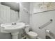 Bathroom featuring a white pedestal sink, toilet, and grab bar for accessibility at 5015 S 88Th St, Tampa, FL 33619