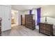 This bedroom features wood-look floors, an adjacent bath, and modern window treatments at 5015 S 88Th St, Tampa, FL 33619