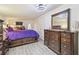 Bedroom features hard surface flooring, a ceiling fan, a door to outside, and a dresser with mirror at 5015 S 88Th St, Tampa, FL 33619
