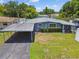 Home's exterior with a carport and green lawn at 5015 S 88Th St, Tampa, FL 33619