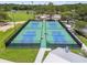 Aerial shot of four fenced pickleball courts with nets, benches, and manicured green surroundings for active recreation at 5015 S 88Th St, Tampa, FL 33619