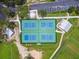 Aerial view of four tennis courts, showing the green and blue surface, with a covered seating area on either side at 5015 S 88Th St, Tampa, FL 33619