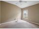 A simple carpeted bedroom with a ceiling fan and window, offering a basic yet functional space at 509 Delwood Breck St, Ruskin, FL 33570