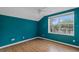 Bright bedroom with laminate flooring and a large window overlooking the neighborhood at 509 Delwood Breck St, Ruskin, FL 33570
