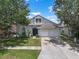 Charming single-Gathering home featuring a two-car garage, well-maintained lawn, and mature trees at 509 Delwood Breck St, Ruskin, FL 33570