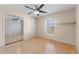 Bright bedroom features a ceiling fan, hardwood floors, and a mirrored closet at 5309 Spectacular Bid Dr, Wesley Chapel, FL 33544
