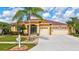 Charming single-story home boasting a two-car garage, lush landscaping, and mature palm trees at 5309 Spectacular Bid Dr, Wesley Chapel, FL 33544