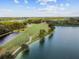 Aerial view of the golf course bordering the lake with a natural setting at 5309 Spectacular Bid Dr, Wesley Chapel, FL 33544