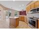 Open kitchen with stainless steel appliances, center island, and sliding glass doors to outdoor space at 5309 Spectacular Bid Dr, Wesley Chapel, FL 33544