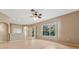 Open living room with hardwood floors, a ceiling fan, a bar, and sliding glass doors at 5309 Spectacular Bid Dr, Wesley Chapel, FL 33544
