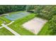Aerial view of community sports courts, featuring a basketball court and sand volleyball court at 5309 Spectacular Bid Dr, Wesley Chapel, FL 33544