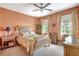 Well-lit bedroom with a ceiling fan, two large windows, and wood furniture at 5518 Luminar Pointe Ln, Apollo Beach, FL 33572