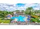 Community pool area with ample lounge seating and waterslide surrounded by manicured grounds and palm trees at 5518 Luminar Pointe Ln, Apollo Beach, FL 33572