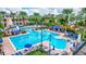 A refreshing pool with plenty of lounge chairs surrounded by tall palm trees and manicured grounds at 5518 Luminar Pointe Ln, Apollo Beach, FL 33572