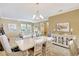 Open-concept dining room features a chandelier, neutral decor, and access to the living room at 5518 Luminar Pointe Ln, Apollo Beach, FL 33572