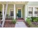 Inviting front porch with grand columns and brick landing, leading to the front door at 5518 Luminar Pointe Ln, Apollo Beach, FL 33572