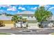 Two-story townhome with a green facade, two-car garage, and well-maintained landscaping creating curb appeal at 5518 Luminar Pointe Ln, Apollo Beach, FL 33572