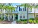 Inviting two-story home featuring a manicured lawn, columns, and a charming walkway to the front door at 5518 Luminar Pointe Ln, Apollo Beach, FL 33572