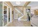 Elegant foyer featuring marble floors, a chandelier, a staircase, and views into the living room at 5518 Luminar Pointe Ln, Apollo Beach, FL 33572