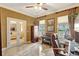 Well-lit home office featuring a piano, a marble floor, and access to the living room through french doors at 5518 Luminar Pointe Ln, Apollo Beach, FL 33572