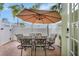 Outdoor seating with umbrella, chairs and patio. White decorative fence and trees in background at 5518 Luminar Pointe Ln, Apollo Beach, FL 33572