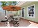 Cozy patio with brick pavers, outdoor seating under an umbrella, perfect for relaxing or entertaining guests at 5518 Luminar Pointe Ln, Apollo Beach, FL 33572