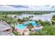 Aerial view of a luxurious community pool featuring a slide, splash pad, lounge chairs, and lush tropical landscaping at 5518 Luminar Pointe Ln, Apollo Beach, FL 33572