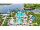 Aerial view of community pools with waterslides, docks, cabanas, lounge chairs, and pristine blue waters at 5518 Luminar Pointe Ln, Apollo Beach, FL 33572