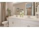 Bathroom featuring double vanity with white cabinetry, quartz countertop, decorative mirror, and shower at 719 Steel Dr, Apollo Beach, FL 33572